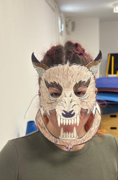 Oseba s pustno masko izdelano na delavnici izdelovanja pustnih mask